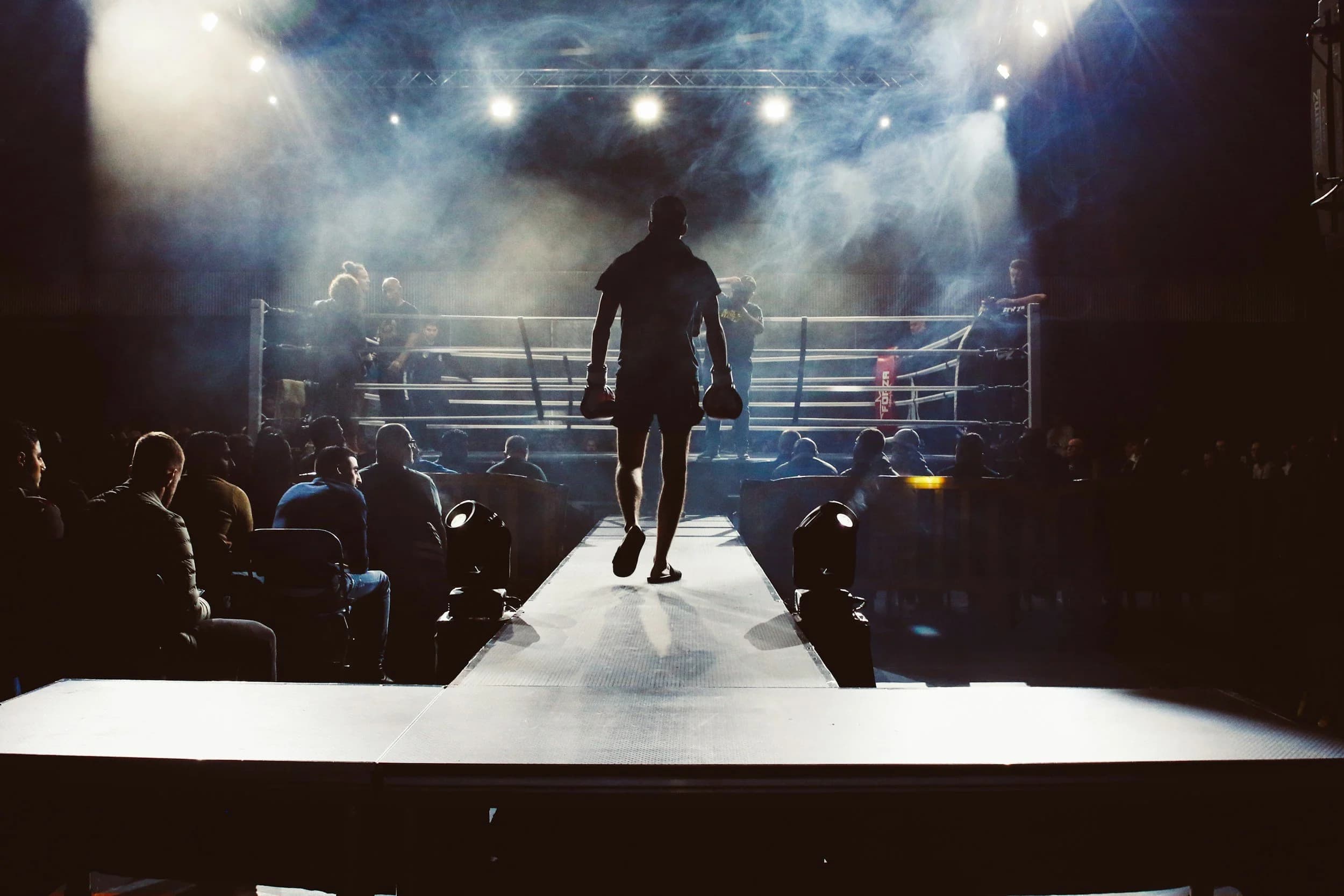 A Moreno Boxing fighter walking towards a lit boxing ring
